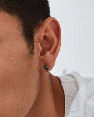 Model wearing Stephen Webster New Cross black-diamond stud earring — visible on ear, showing size, sparkle and gold finish