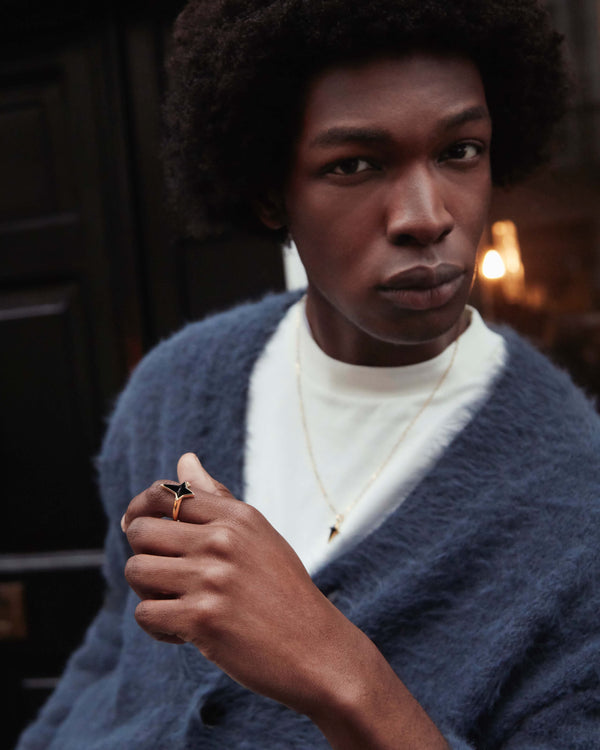 Model wearing Stephen Webster New Cross black onyx ring — showing ring fit, gold finish and onyx detail on finger