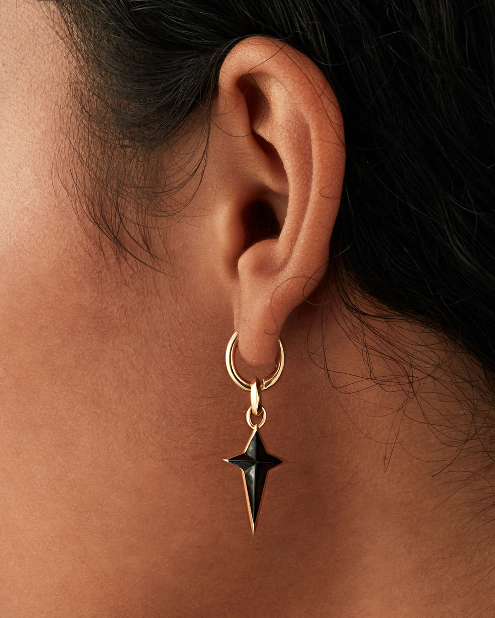 Stephen Webster New Cross single earring charm in 18 ct yellow gold with black onyx inlay — front view showing cross motif