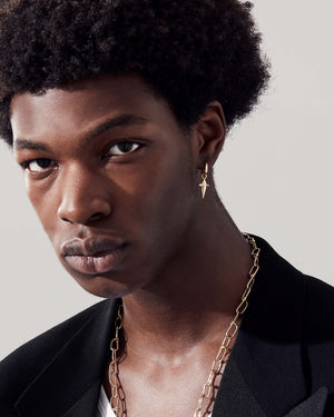 Model wearing the Stephen Webster New Cross gold charm — charm visible on ear, drop length shown