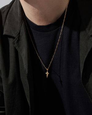 Model wearing Stephen Webster New Cross malachite pendant on gold chain — back of pendant visible on chest, highlighting size