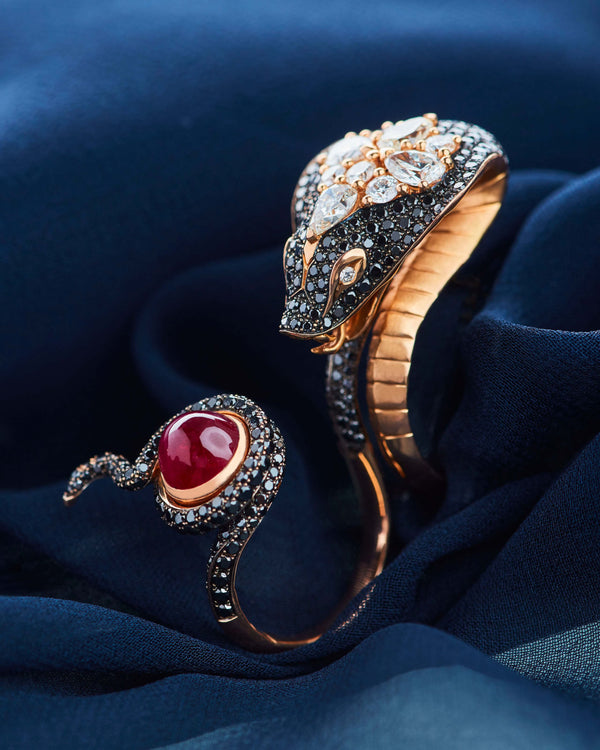 Close-up of the Stephen Webster All About Eve rose gold ring showcasing a central ruby surrounded by black and white diamond pavé, a bold luxury statement ring