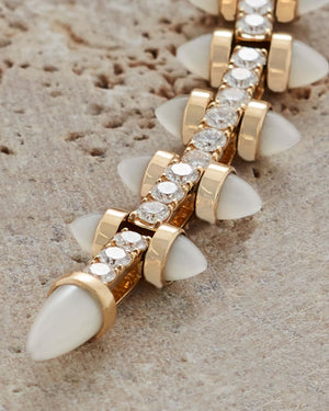 Close-up of the Stephen Webster Russian Roulette Magazine necklace highlighting pavé-set white diamonds and precision-crafted yellow gold magazine design