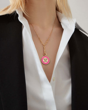 Close-up of the Stephen Webster Setting Lotion 18 ct gold pendant worn on model’s neck, showing lapis enamel vinyl design and engraved lettering