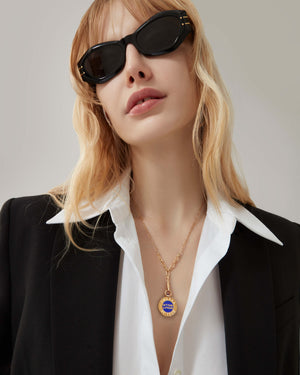 Model wearing the Stephen Webster Setting Lotion gold pendant necklace — showing pendant size, gold chain and enamel detail