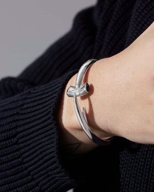 Close-up of model’s wrist wearing Stephen Webster Hammerhead cuff bangle — showing curved form and polished surface