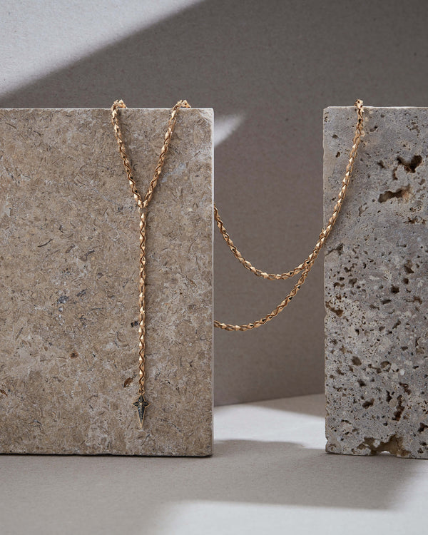 Stephen Webster Superstud New Cross gold chain necklace hanging — showing pendant drop and chain design with black diamond cross pendant