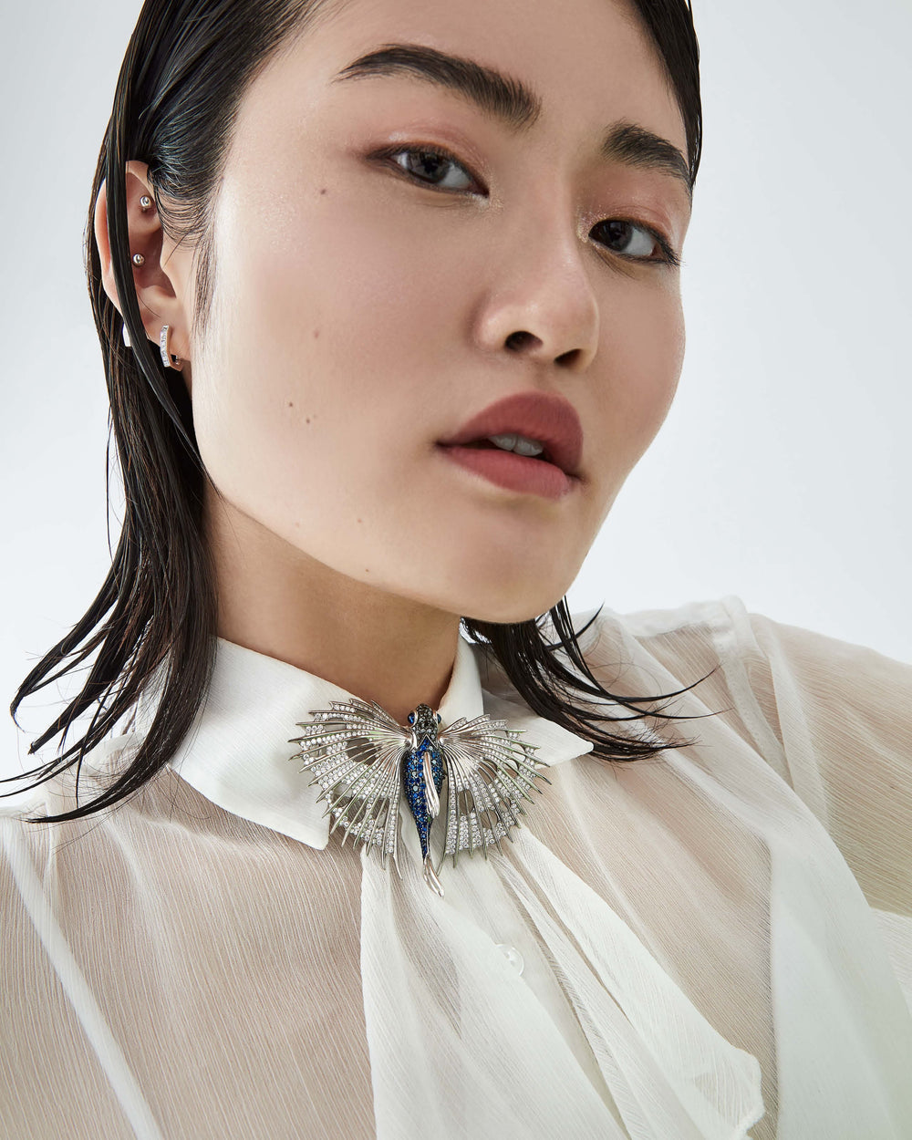 Stephen Webster Flying Fish brooch in titanium and 18ct white gold with blue sapphires, black diamonds and sapphire cabochon eyes, luxury British fine jewellery