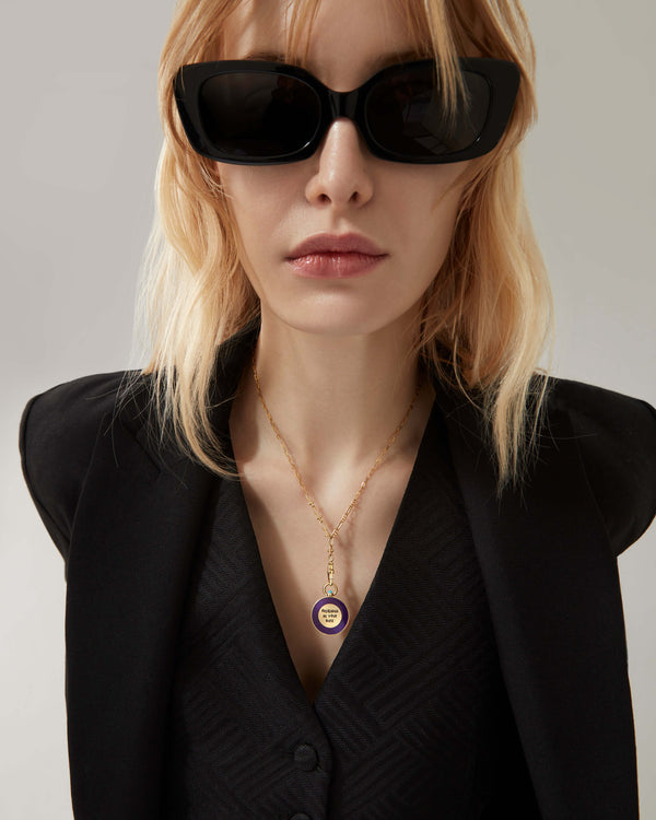Female model wearing Stephen Webster Vacuum Cleaner gold pendant on chain — showing pendant size, enamel detail and gold finish