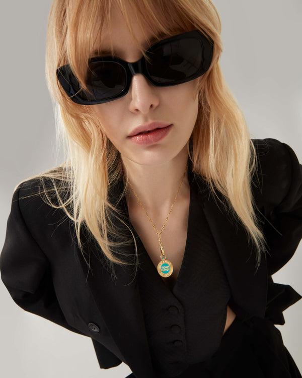 Female model wearing Stephen Webster Vacuum Cleaner gold pendant on chain — showing pendant size, enamel detail and gold finish