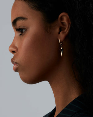 Model wearing Stephen Webster yellow gold sleeper earring — hoop visible on ear, showing size and shine