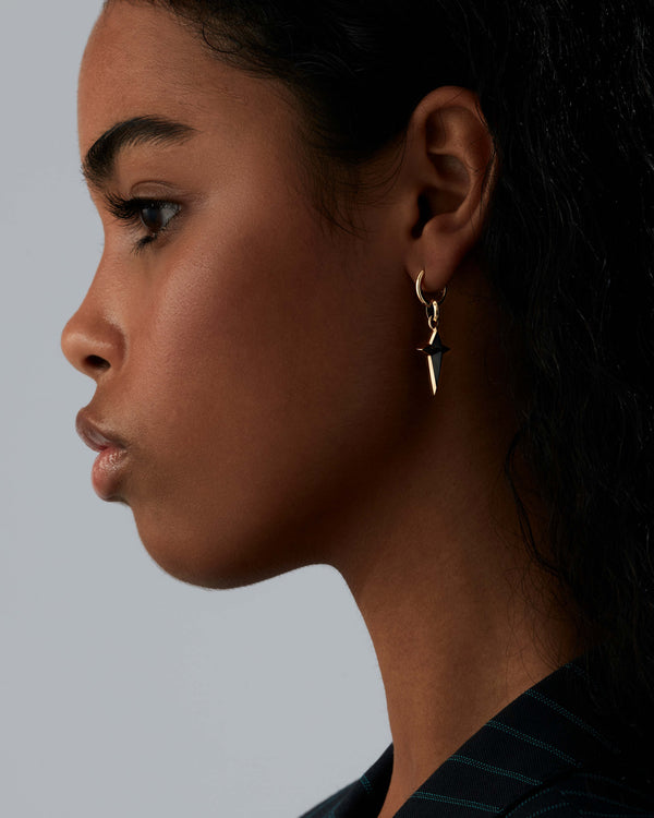 Model wearing Stephen Webster yellow gold sleeper earring — hoop visible on ear, showing size and shine