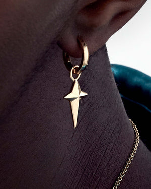 Model wearing Stephen Webster yellow gold sleeper earring — hoop visible on ear, showing size and shine