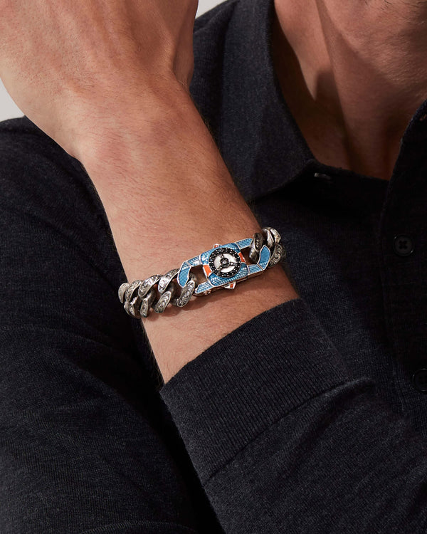 Model wearing Stephen Webster Great Escape clasp in sterling silver with black diamond pavé, blue & orange enamel and mother of pearl back plate