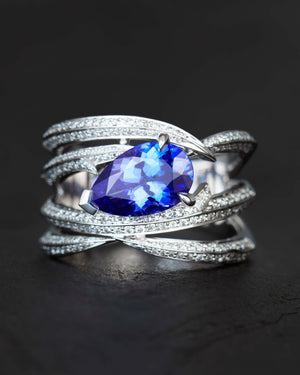 Close-up of central pear-shaped tanzanite and white diamond pavé on the Entangled Tanzanite Band Ring in 18ct white gold