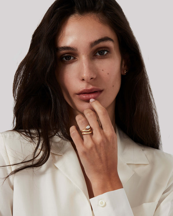 Yellow gold Thorn Floating Solitaire Slimline diamond wedding band styled with matching engagement ring on hand