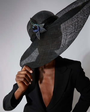 Model wearing Titanium Flight Encounter Brooch pinned on hat — blue titanium gemstone brooch