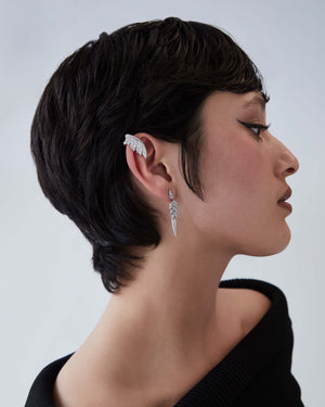 White gold and white diamond tail feather drop earrings worn on ear showcasing feather jewellery design