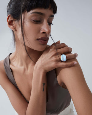 White opalescent Crystal Haze amplified cocktail ring worn on hand in 18ct yellow gold with white diamonds