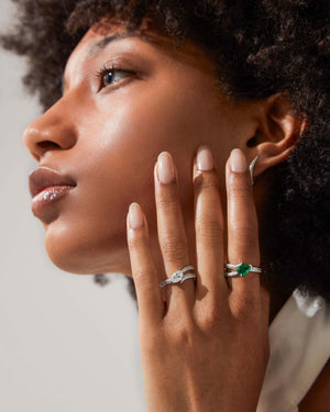Model wearing 18ct white gold Opposites Attract diamond and emerald ring separately