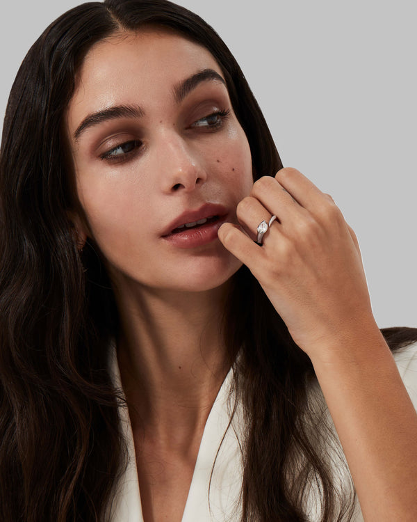 Model wearing platinum Thorn Arc Solitaire Slimline ring with pear-cut diamond