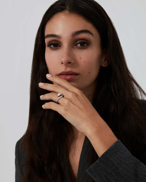 Model wearing platinum Thorn Floating Solitaire Pavé engagement ring with pear-cut white diamond