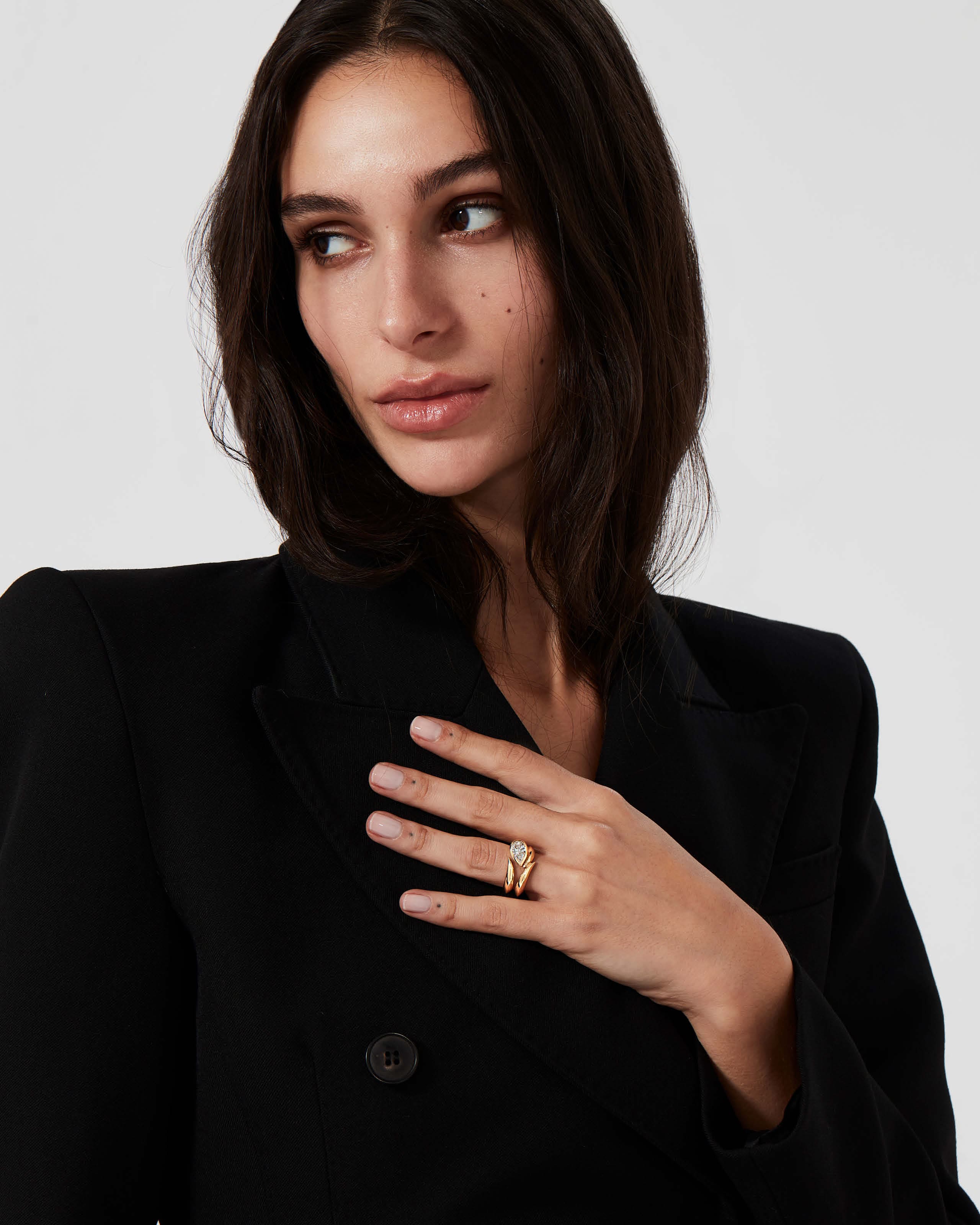 Model wearing Thorn Arc Solitaire ring in yellow gold with pear-cut diamond and matching wedding band.